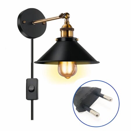Wired industrial wall light with black switch, bracket and shade and gold stem. The bulb is lit, small round label at bottom right with image of EU plug.