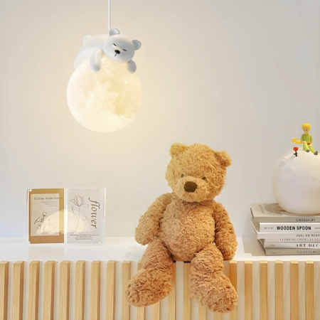 Wall lamp with a bear sleeping on the moon hanging in a baby's room and next to a large teddy bear