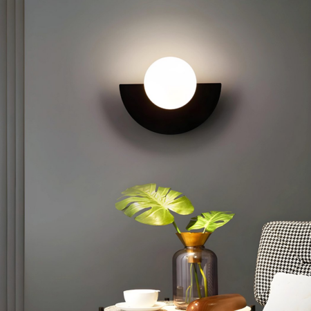 Retro half-moon wall light hung in a living room next to a plant in a vase