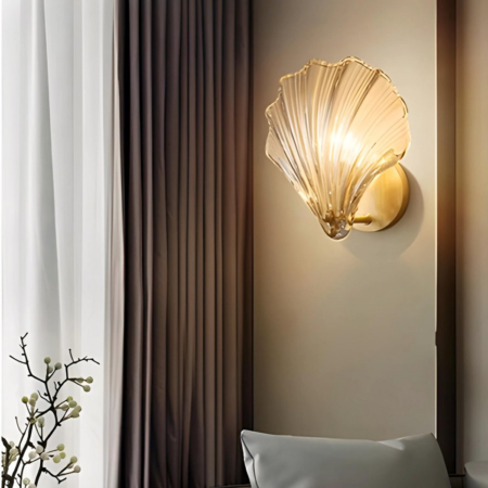 Seashell wall lamp hung next to curtains and a plant in a living room