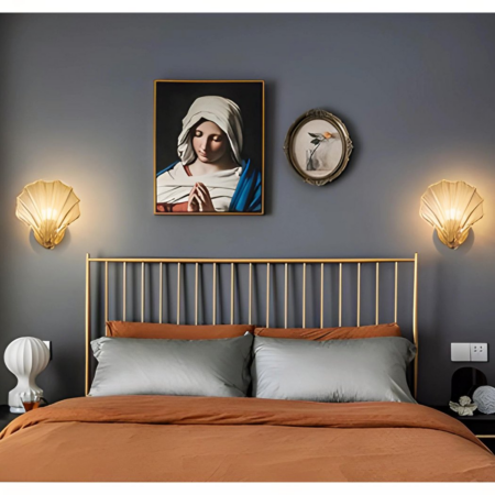 Two shell wall sconces hung next to a picture frame in a bedroom