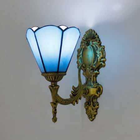 Tiffany-style wall light with blue flower shade. The base is bronze.