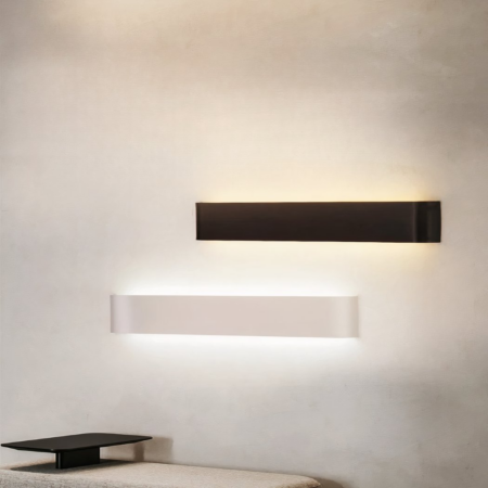 a black rectangular wall light and a white rectangular wall light on a beige wall with a table underneath.