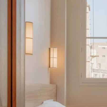 we see a japanese hotel room with beige walls and two luxurious japanese fabric sconces