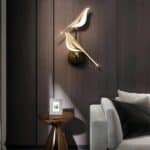 Wall lights with two golden magpies on a brown background in a living room
