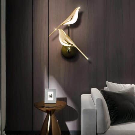 Wall lights with two golden magpies on a brown background in a living room
