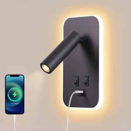 Beige wall-mounted reading light with one light source against the wall and another via a rotating front sport, lighted by two switches and with a USB socket where a phone is plugged in for charging.