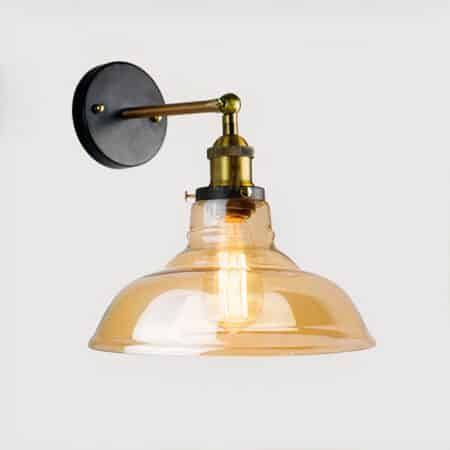 a wall light with transparent amber shade in industrial style is seen on a light wall