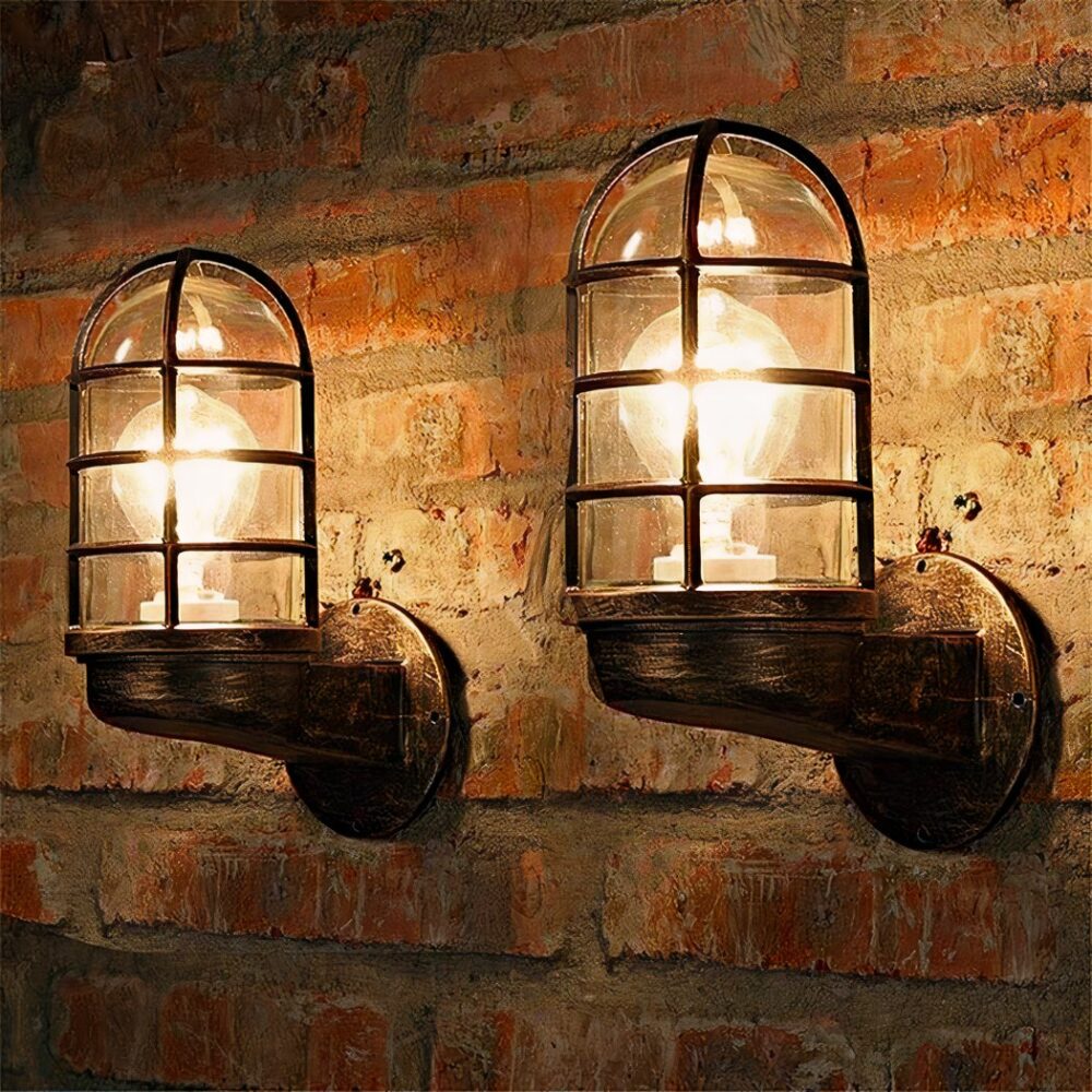 on a red brick wall, two industrial-style interior wall sconces with caged lamp