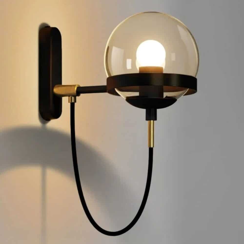 we see a retro-style kitchen wall light in black and gold on a light gray wall