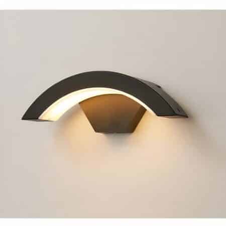 Half-moon-shaped wall light in black aluminum with LEDs lit from below, mounted on a white wall.