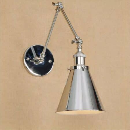 on a brown wall, we see an industrial vintage-style silver wall light with a folding arm