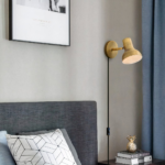 An industrial-style wired wall light in gold as a headboard