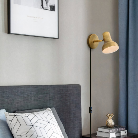 Industrial-style wired wall light An industrial-style wired wall light in gold as a headboard