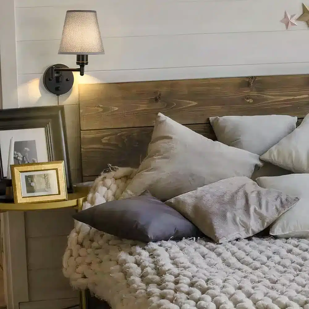 A wired wall light with folding arm in black metal fixed in a bedroom