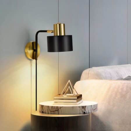 Wired black and gold wall light on bedroom wall