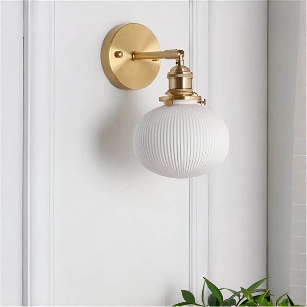 Ceramic ball wall light mounted on a white wall with moldings.