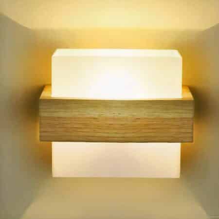 on a light grey wall, a Japanese-style square wooden wall lamp is lit up