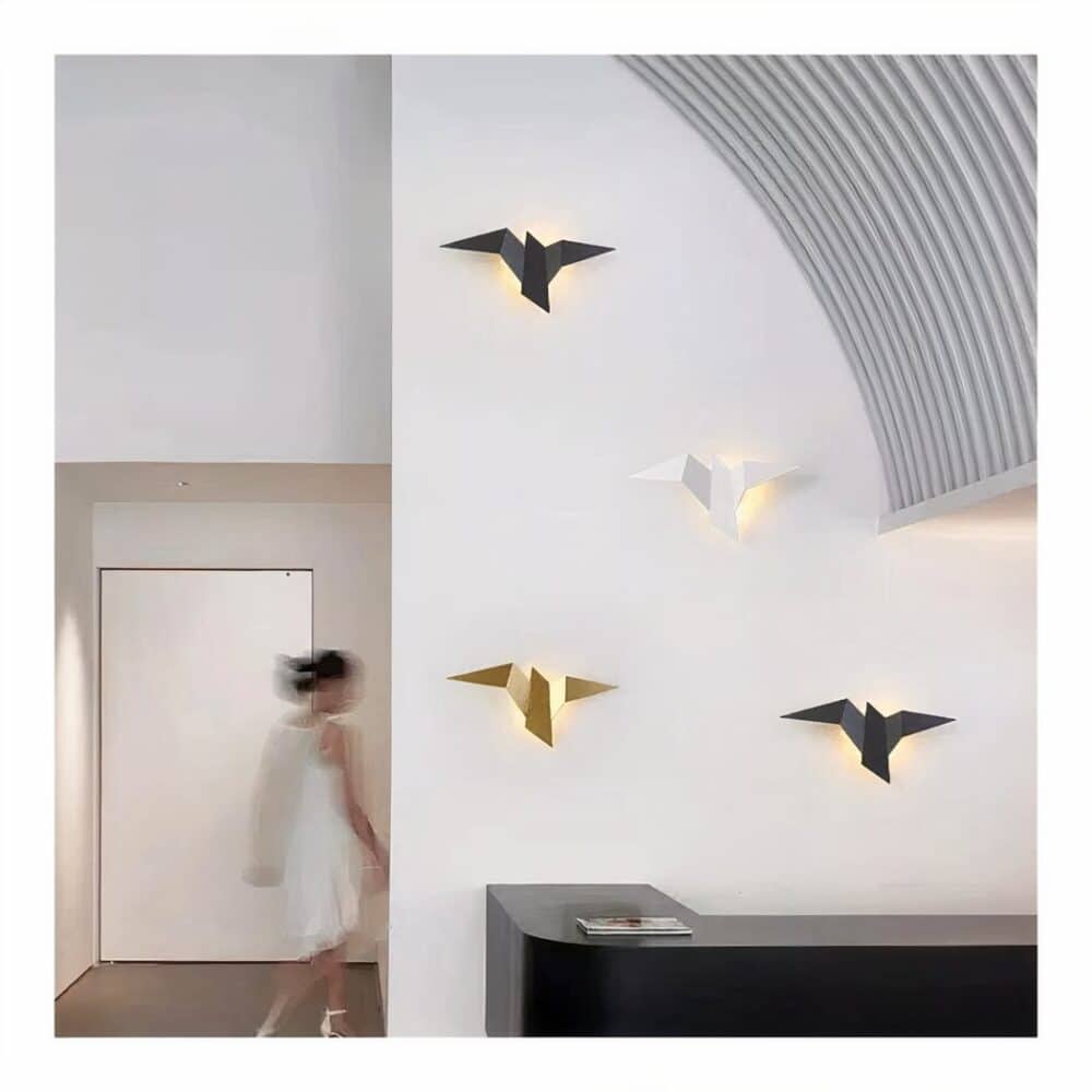 we see a white living room with several black, white and gold bird-shaped metal wall sconces on the wall