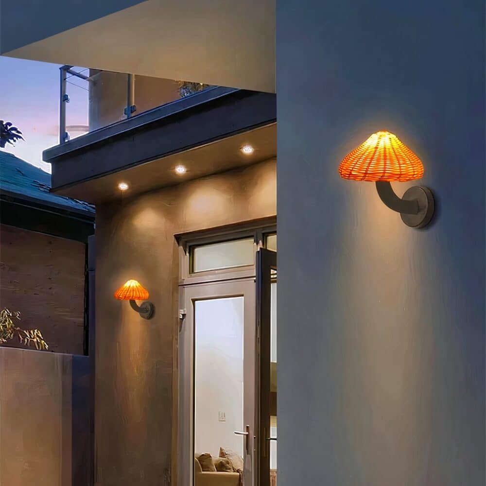 Wicker wall light for indoor and outdoor use, lit and hung on an exterior wall.