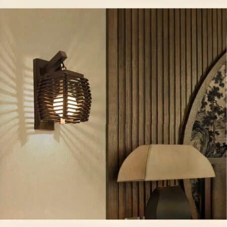 Japanese-style wicker wall light lit and hung on a white wall in a living room.
