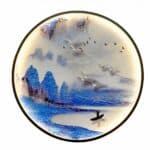 on a white background, we see a round wall sconce with a Japanese landscape