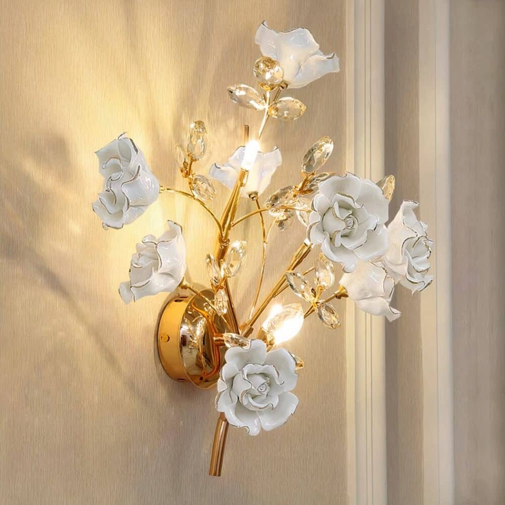 Vintage ceramic flower wall sconce hung on a wall and lit.