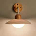 Wall lamp in travertine and wood fixed to a wall with a light bulb.